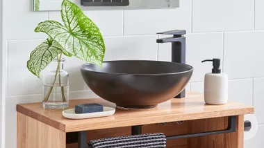 Floating timber bathroom vanity with round, black above-basin sink.