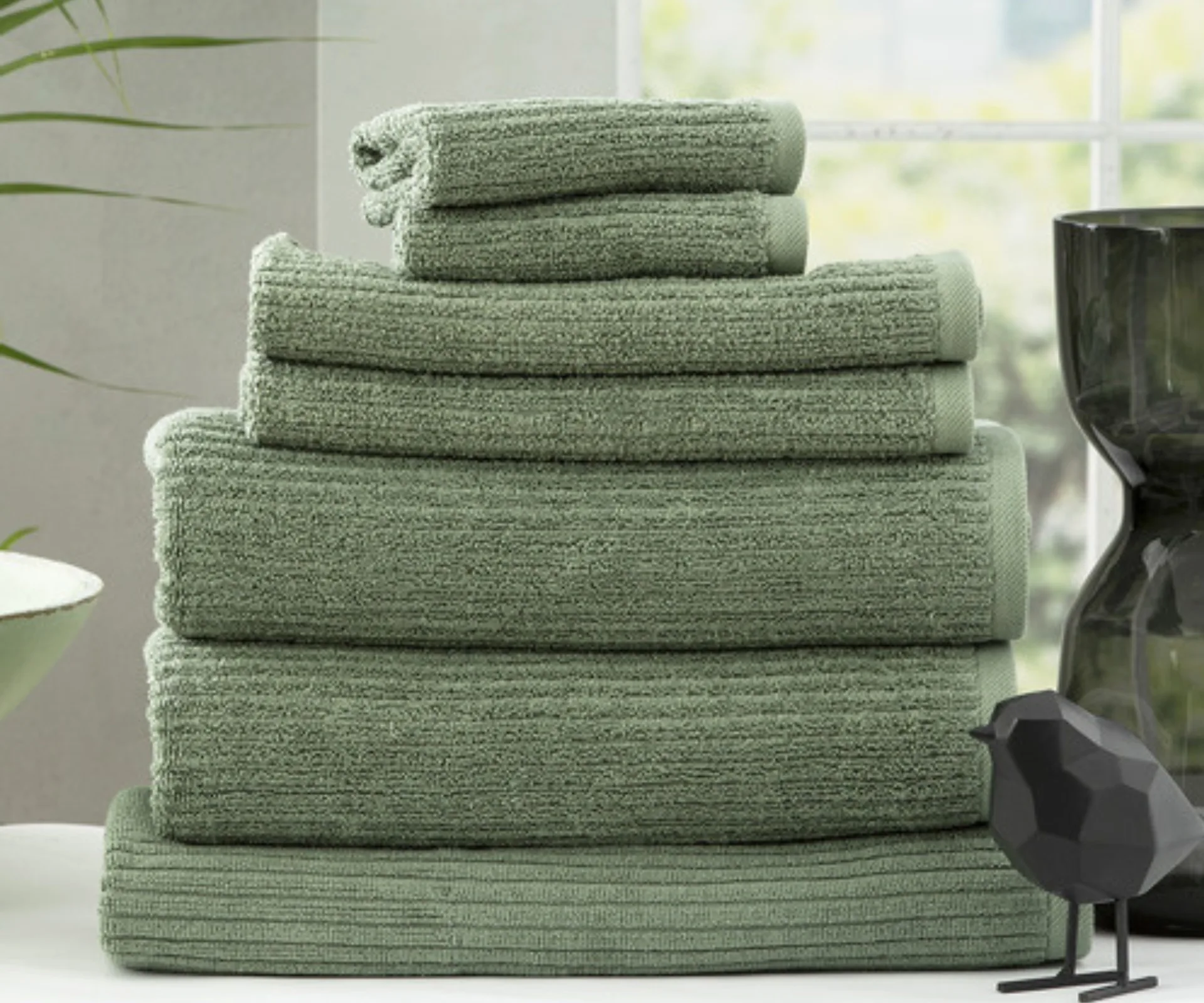 stack of green towels with black bird decor on the side in temple and webster sales