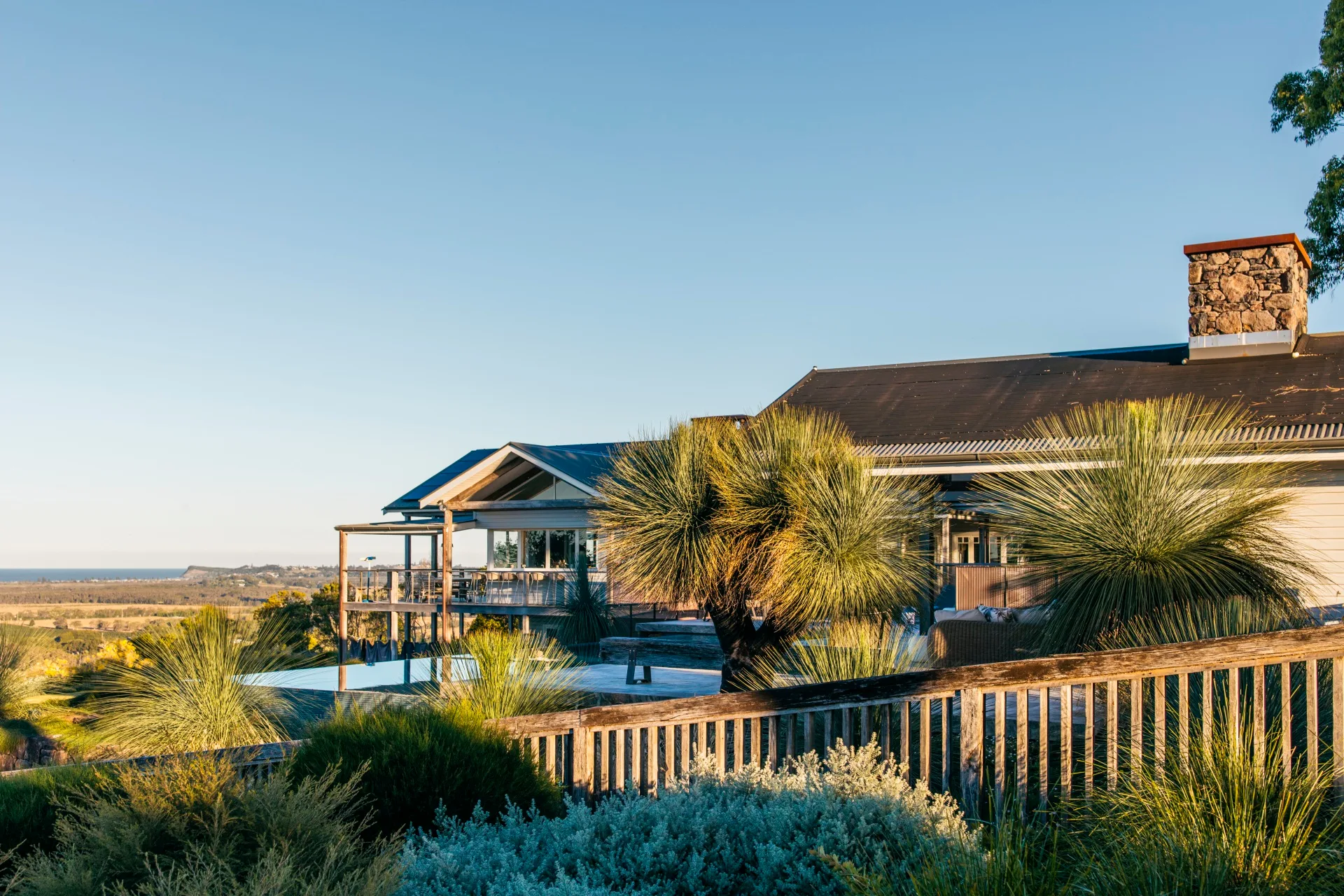 side view of a house with pool in the front and lots of grass trees