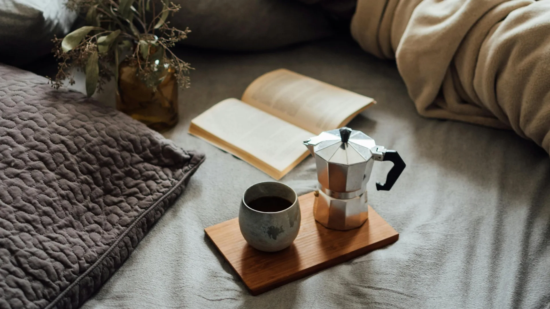 moka pot and coffee cup on breakfast tray on a couch