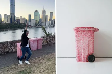 red and white wheelie bin in front of a lake