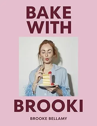 bake with brooki image of cover of cookbook with title and brooki eating cake on the front