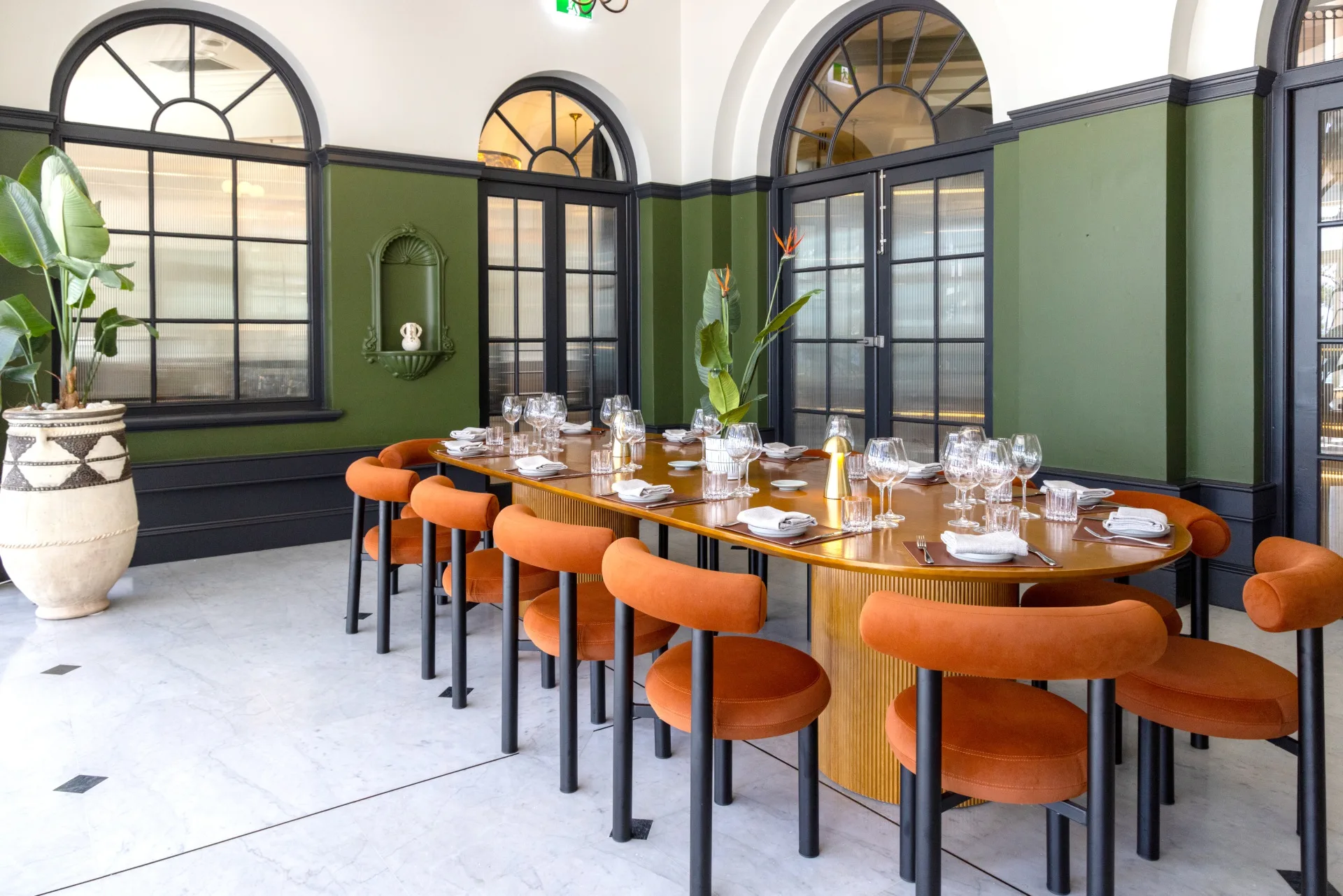 dining room with orange chairs and fancy table setting in crowne plaza