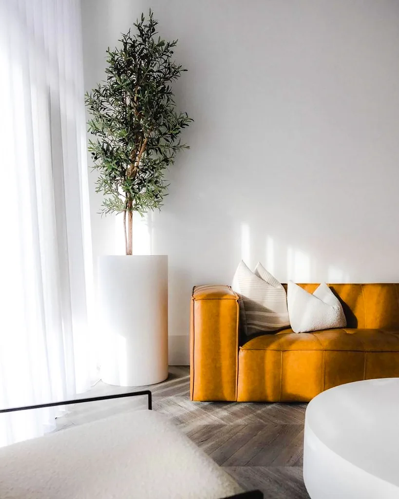 Modern living room with a large artificial olive tree by the window