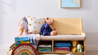 kids book nook with books in bottom sections and chair with cushion to sit on