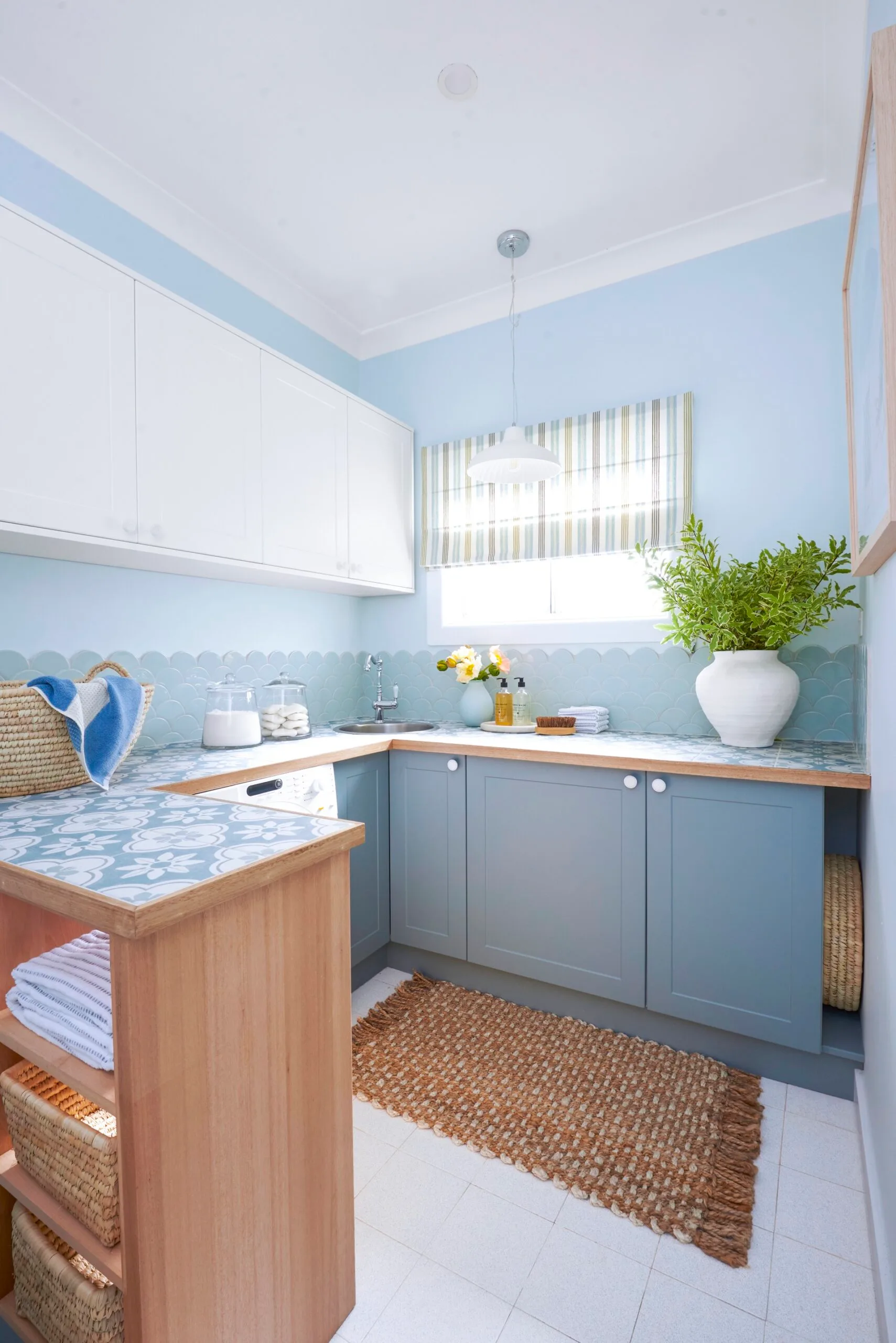 laundry makeover portrait image of new laundry blue scalloped tiles and tiled benchtop