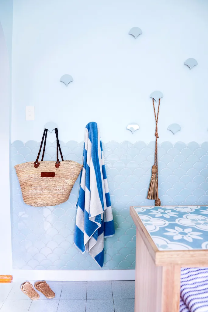 wall hangings with bags and towels and scalloped tiles