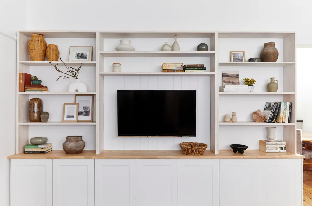 gaiola de móvel de TV com vasos, bugigangas e livros colocados ao redor