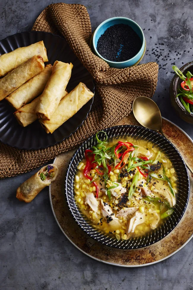 bowl of chicken corn soup with spring roll dippers on the side