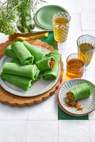 green pancake crepes rolled onto a plate