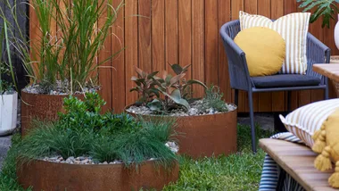 raised garden beds made from corten steel with couch on the side