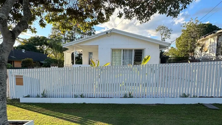after of fence renovation white picket fence in front of white house