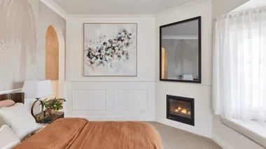 bedroom with in built gas fireplace and pink bedspread