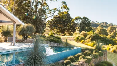 Landscape view of landscaper Grant Boyle's garden with infinity pool and rock retaining wall.