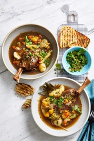 irish stew in two bowls with parsley on the side