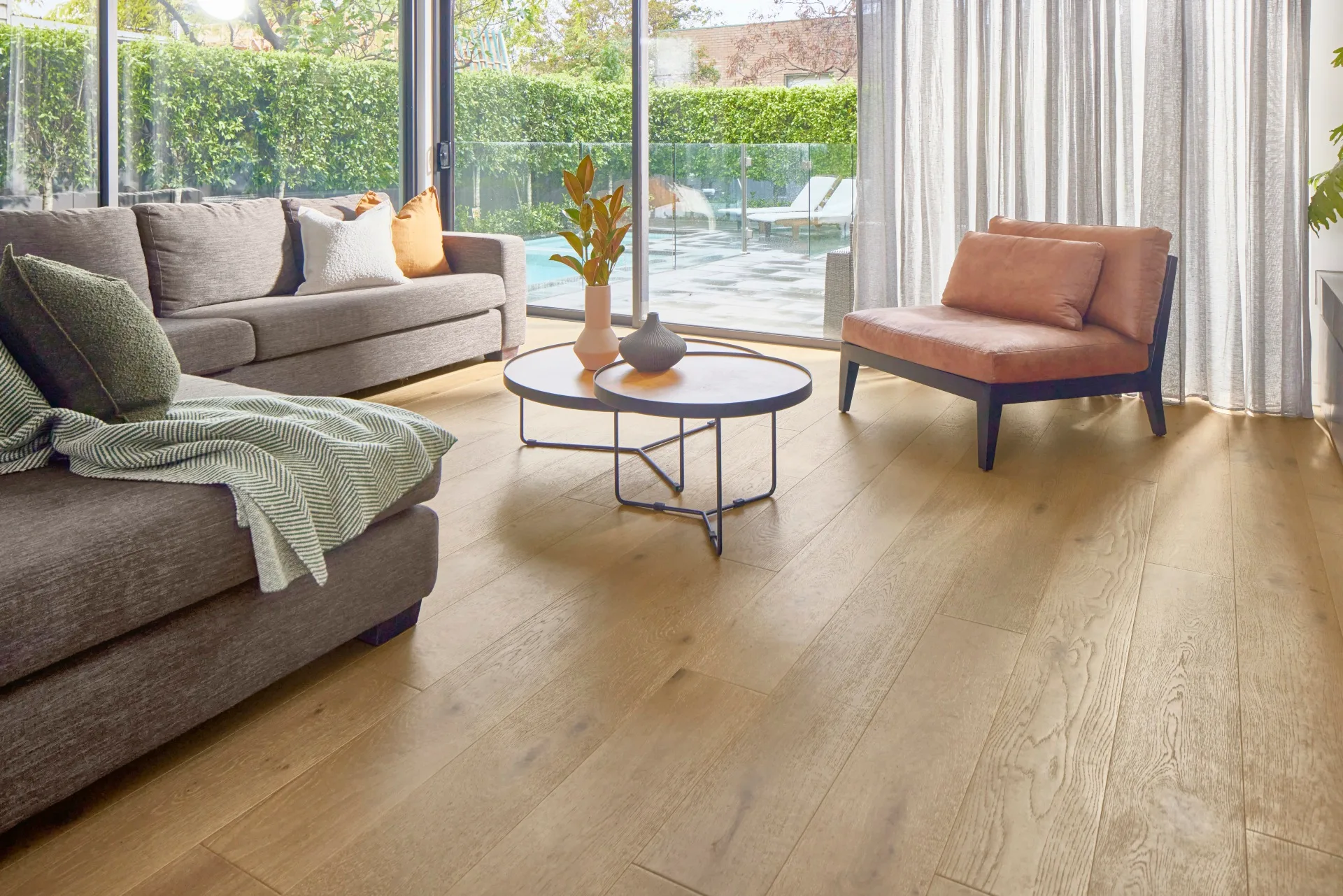 living room with grey couch and tan coloured engineered timber flooring