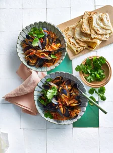 bowls of asian style mussels with roti on the side
