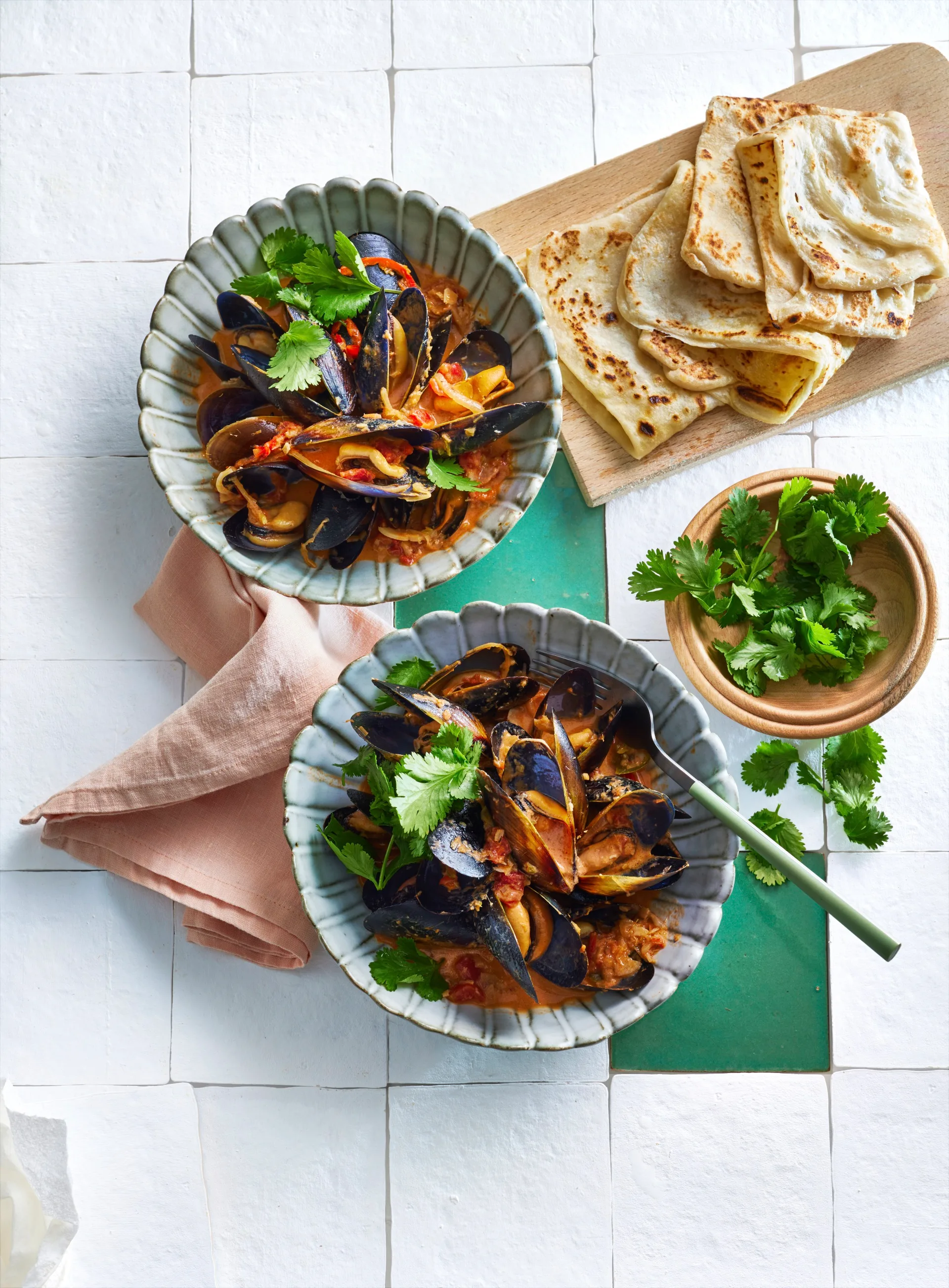 bowls of asian style mussels with roti on the side