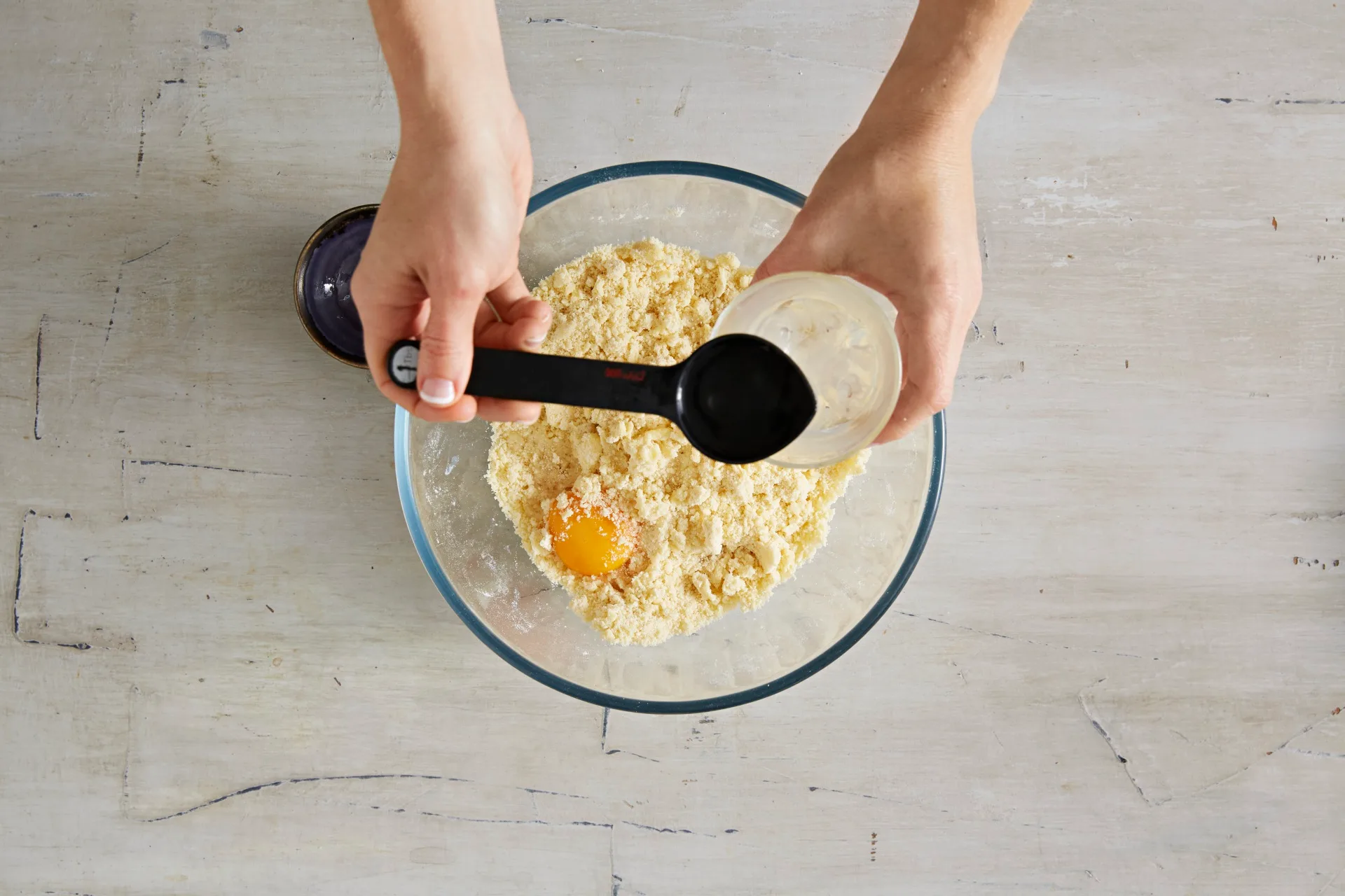 adding in egg yolks and iced water to pastry mixture