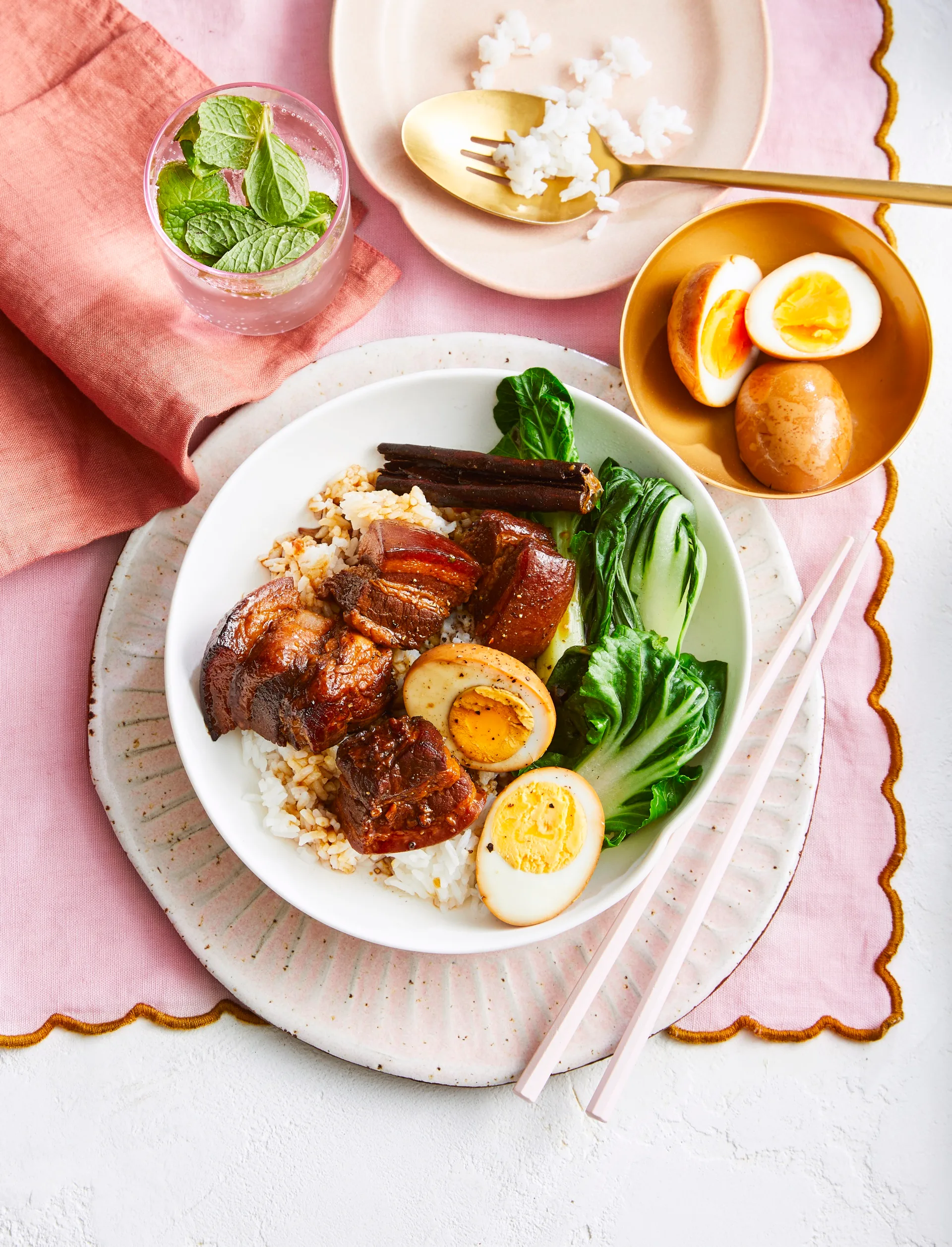 soy braised pork belly in bowl with asian greens and boiled egg cut in half