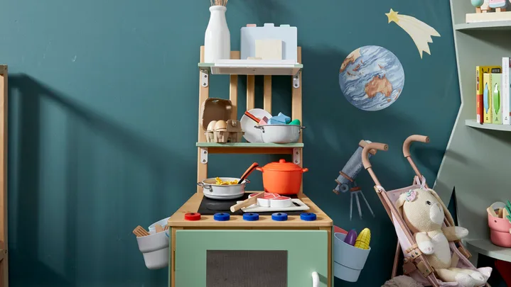 kids play kitchen long shot with chair converted into play equipment in centre