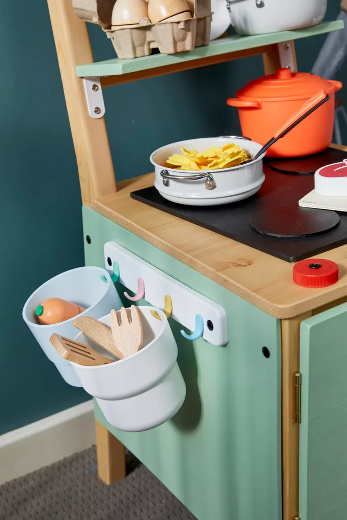 vista lateral da cadeira diy com ganchos para guardar utensílios e equipamentos de cozinha infantil