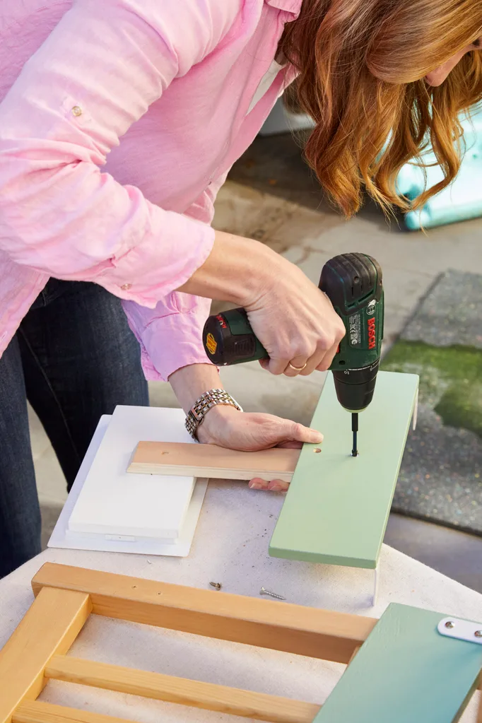 juliet love drilling a hole into diy kids play kitchen component that is light green