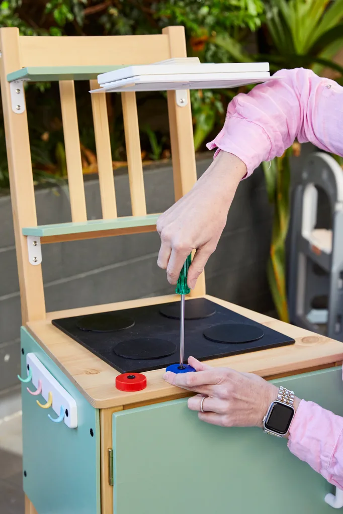 juleit love screwing on bottle caps as twisty knobs in final touch for kitchen play equipment.