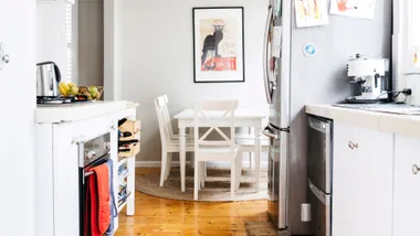 double drawer dishwasher in a narrow kitchen with fridge and dining table