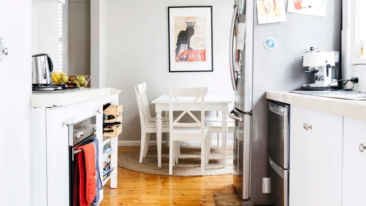 double drawer dishwasher in a narrow kitchen with fridge and dining table