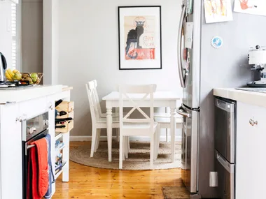 double drawer dishwasher in a narrow kitchen with fridge and dining table