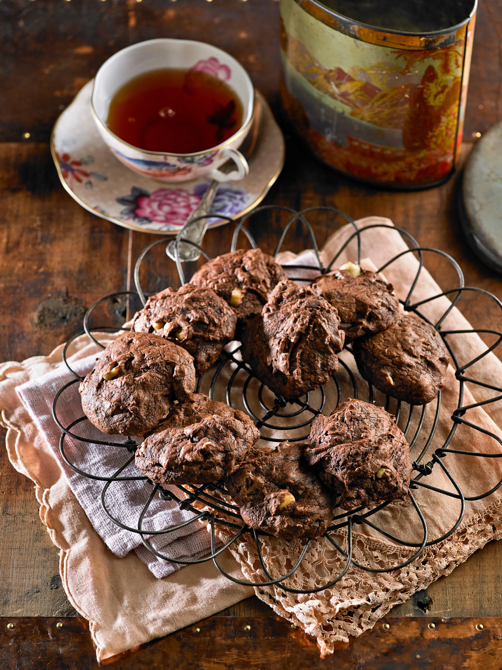 gluten free chocolate biscuits on a wire tray with a teacup in the background