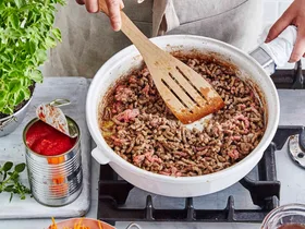 Cooking beef mince in a white frypan