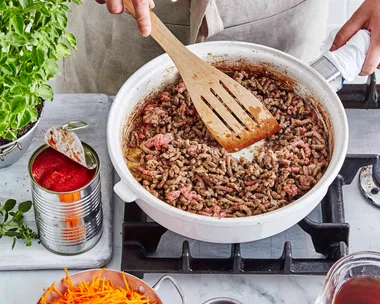 Cooking beef mince in a white frypan