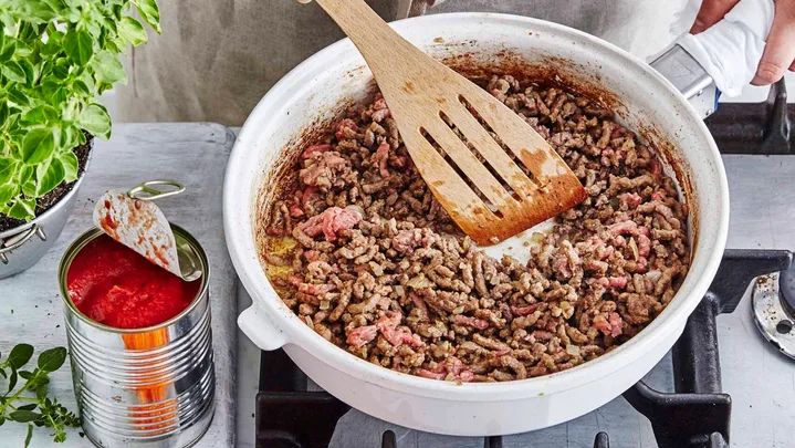 Cooking beef mince in a white frypan