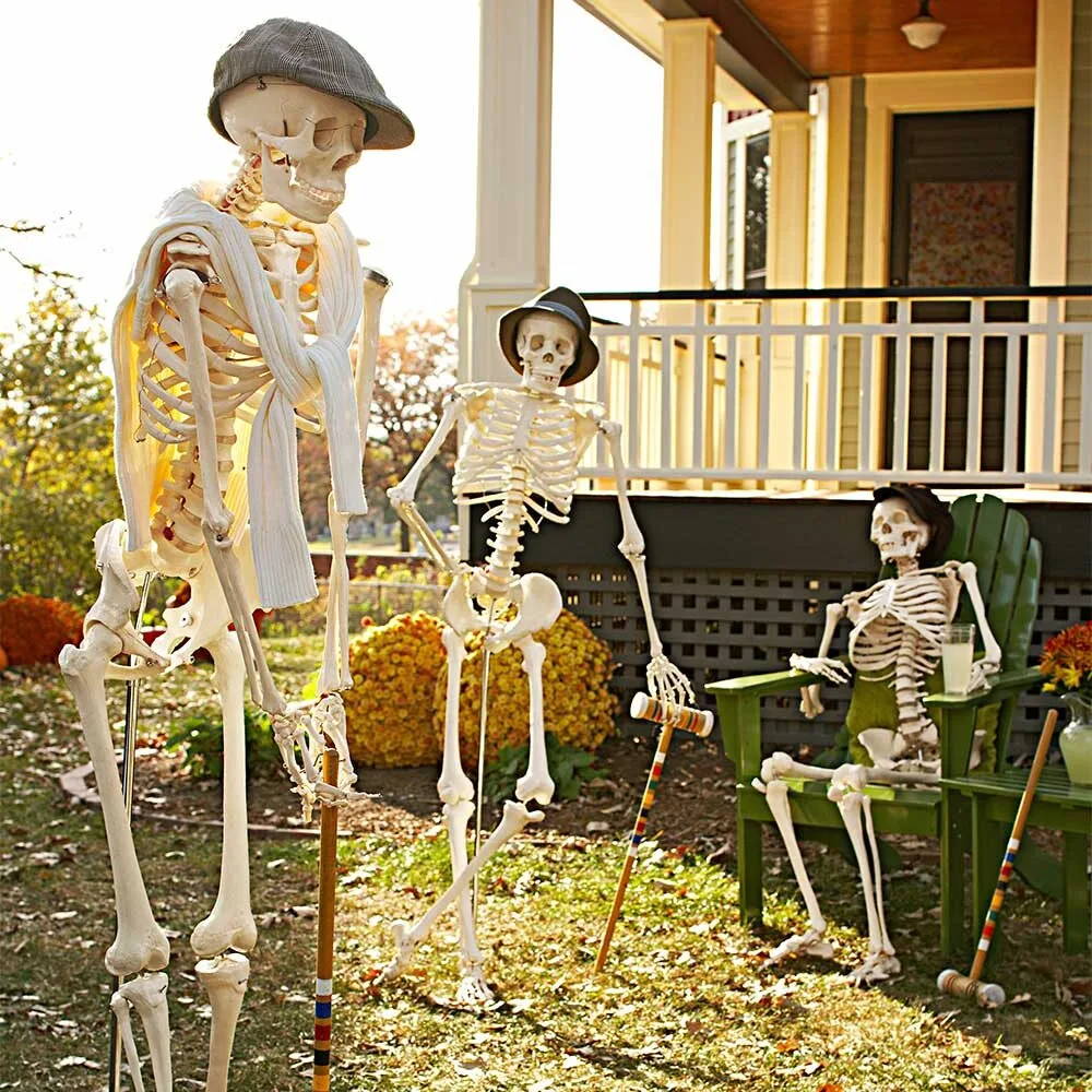 Funny Halloween skeletons posing in front garden