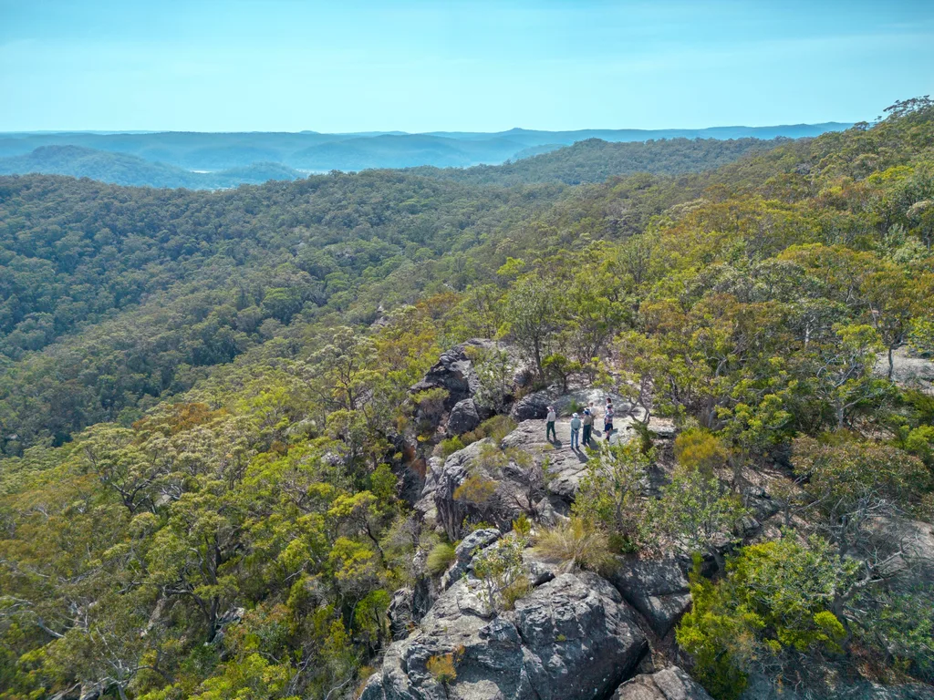 faraway shot of muogamarra reserve big rock formation surrounded by green gum trees