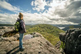 hiker standing on top of rock overlooking nature reserve
