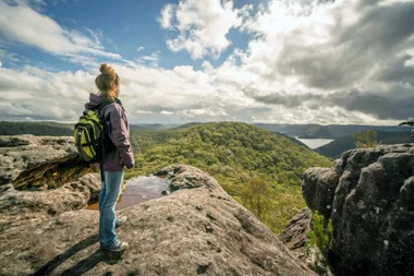 hiker standing on top of rock overlooking nature reserve