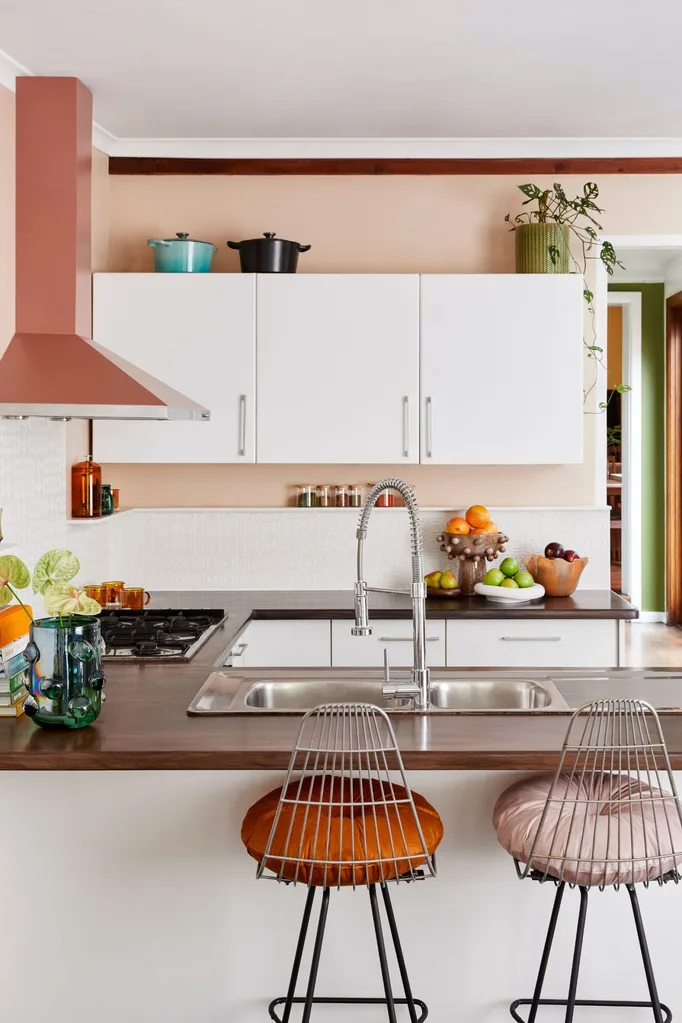 Cozinha com bancos e pintura coral com papel de parede branco pintável