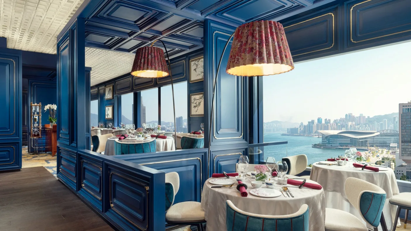 interior shot of the man wah restaurant in the mandarin oriental with blue panelled wallls and very colonial traditional styling.