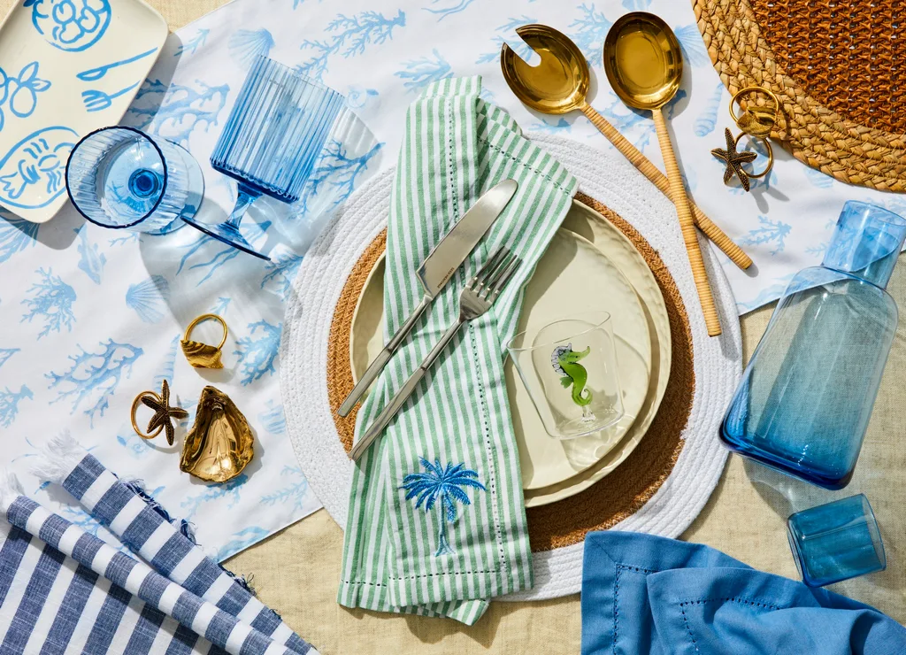 christmas table with blue ocean theme with stripy linen tablecloths seashell accents and blue coloured glass