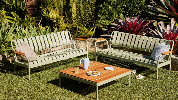 image of two sage green metal lounge seater chairs with wooden table top coffee table in the middle