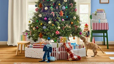 Christmas tree with dogs underneath and lots of presents surrounding him