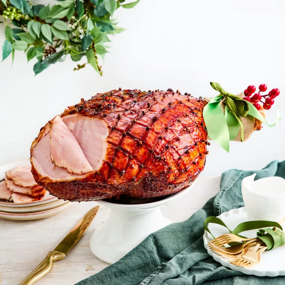 chirstmas ham with green ribbon on the end and garland in the background