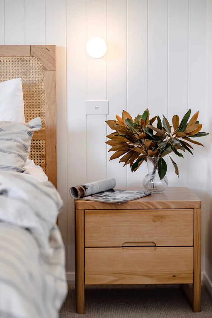 Coastal style bedroom with wall sconce and visible light switch.