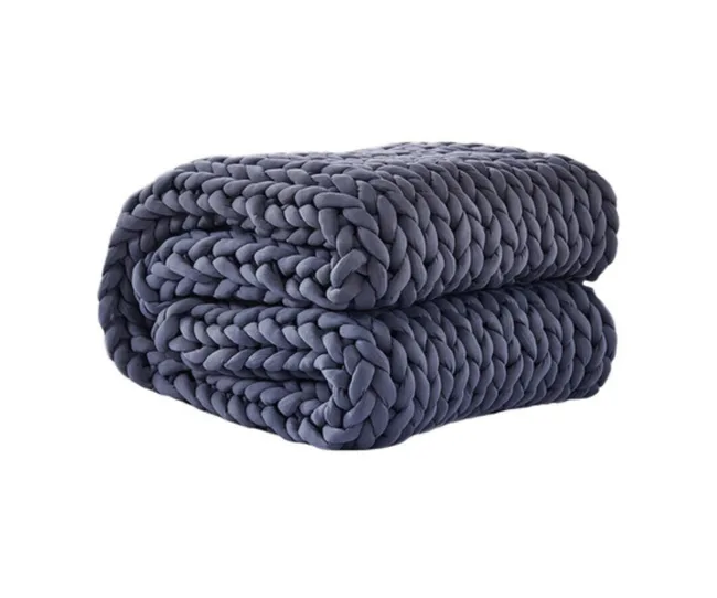 Dark gray, folded chunky knit blanket with thick woven texture against a white background.