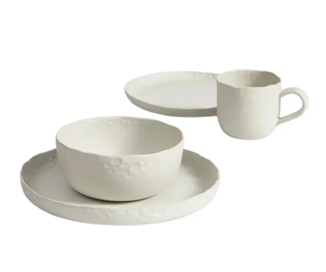 White ceramic dinnerware set with textured bowl, mug, and two plates.