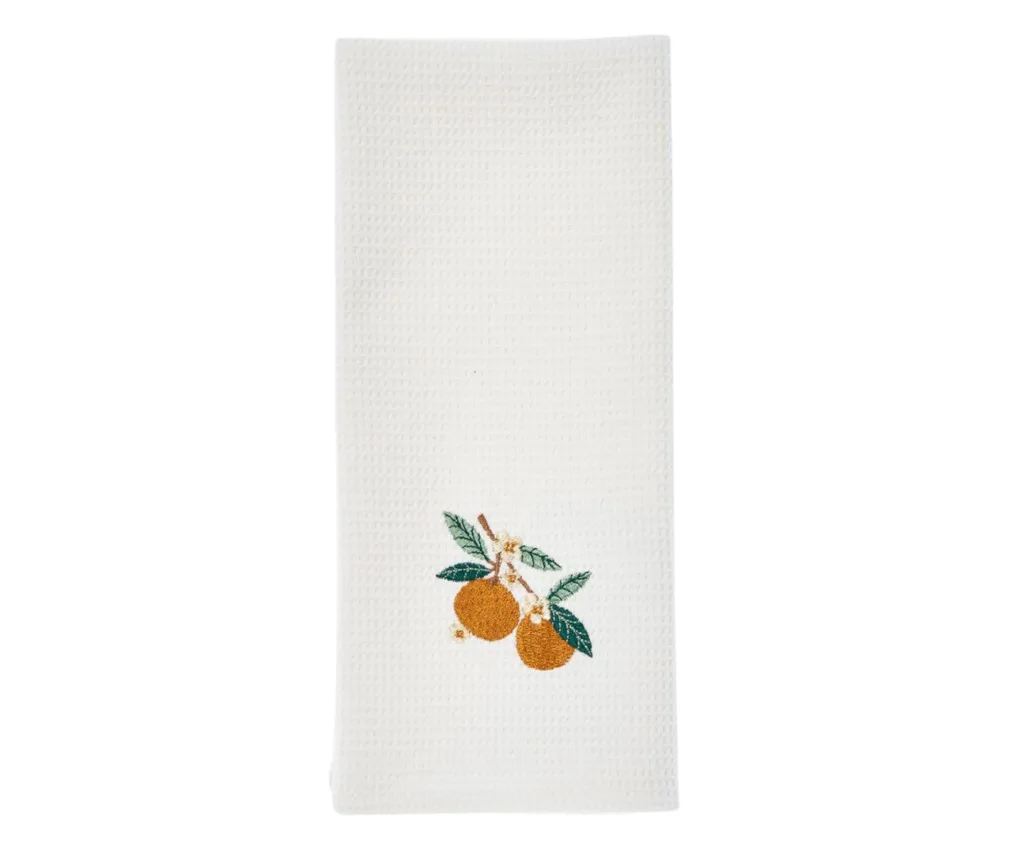 embroidered hand towel with little oranges and orange blossoms on the bottom
