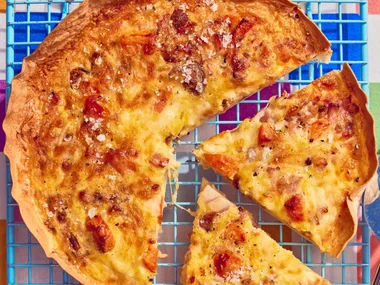 tortilla omelette with slice cut out of it on blue cooling tray